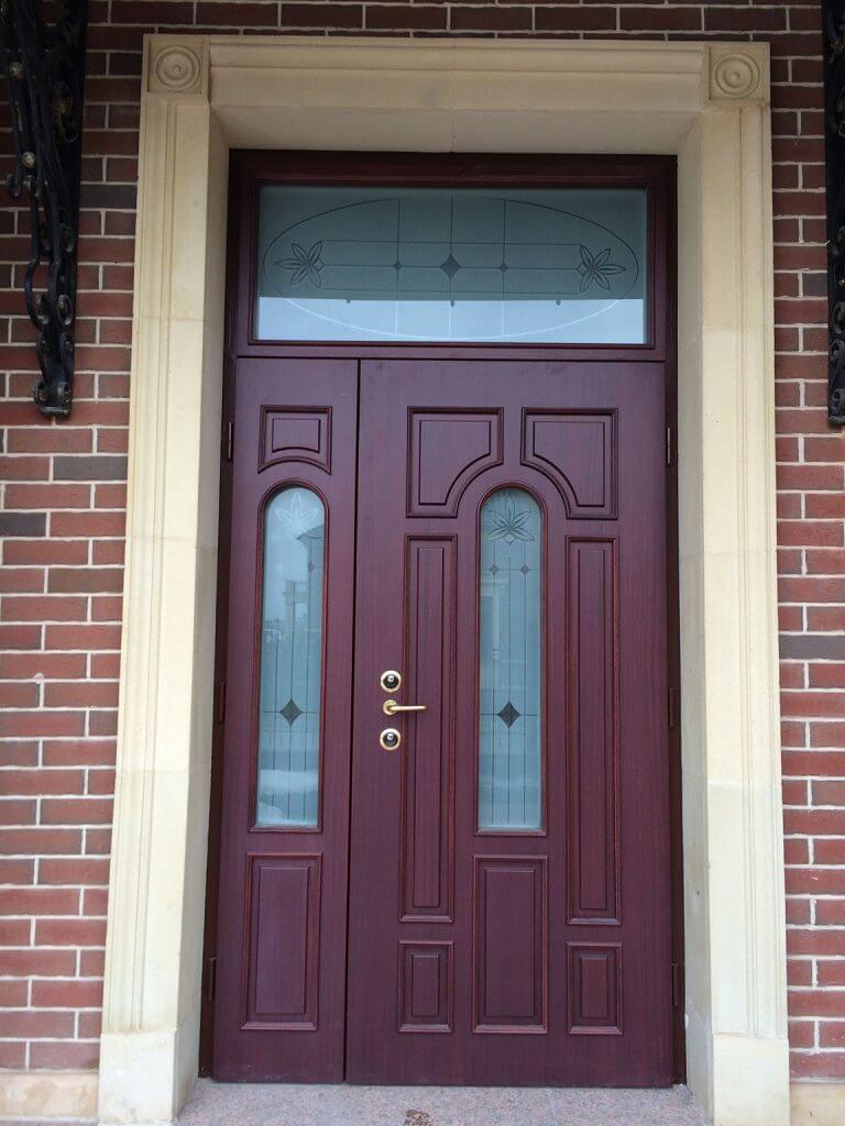 A photo of a luxury front door in a rich mahogany on a brick home.
