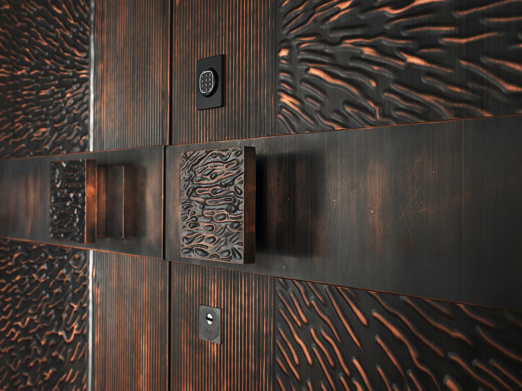 A photo showing a bronze security door with custom luxury door handles.