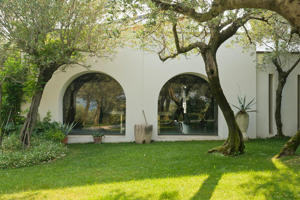 A photo of the courtyard behind a luxury home featuring two large, arched security windows.