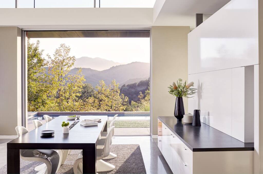 A photo of a bright dining room in a luxury home with a view of the mountains.