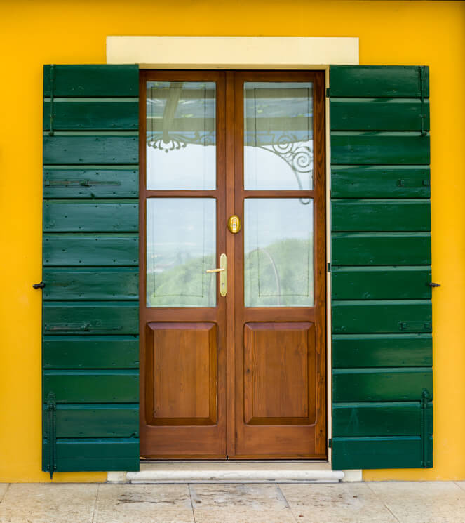 A photo of a wood security door with security glass inserts on an old house in Italy.