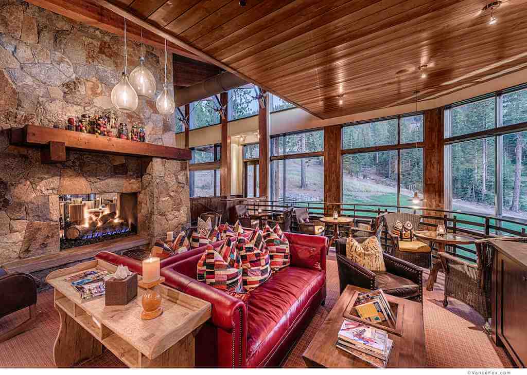 A photo of a rustic luxury home living room featuring large fixed windows.