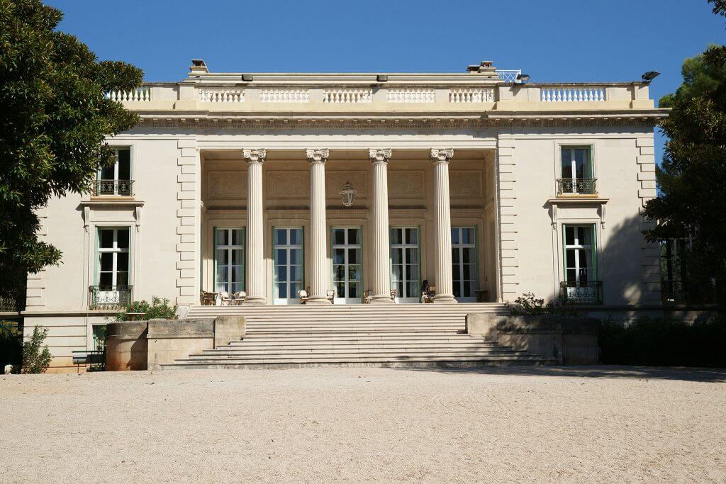 A photo of a mansion with stately columns at the front entrance.