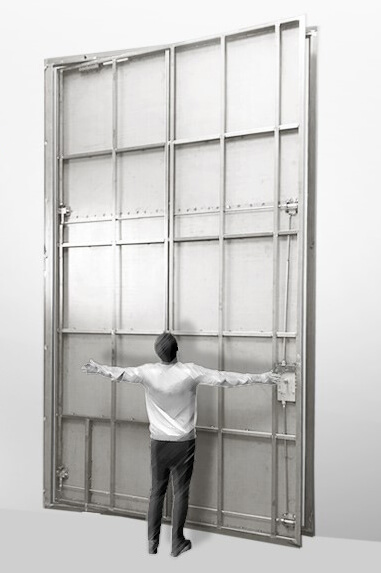 A rendering of an 8-foot by 13-foot steel hurricane certified pivot door with a fully grown man standing in front of it for scale.
