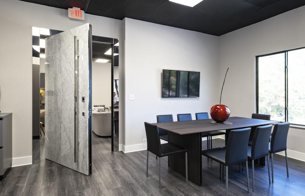 A photo of a large pivot door in an office setting.