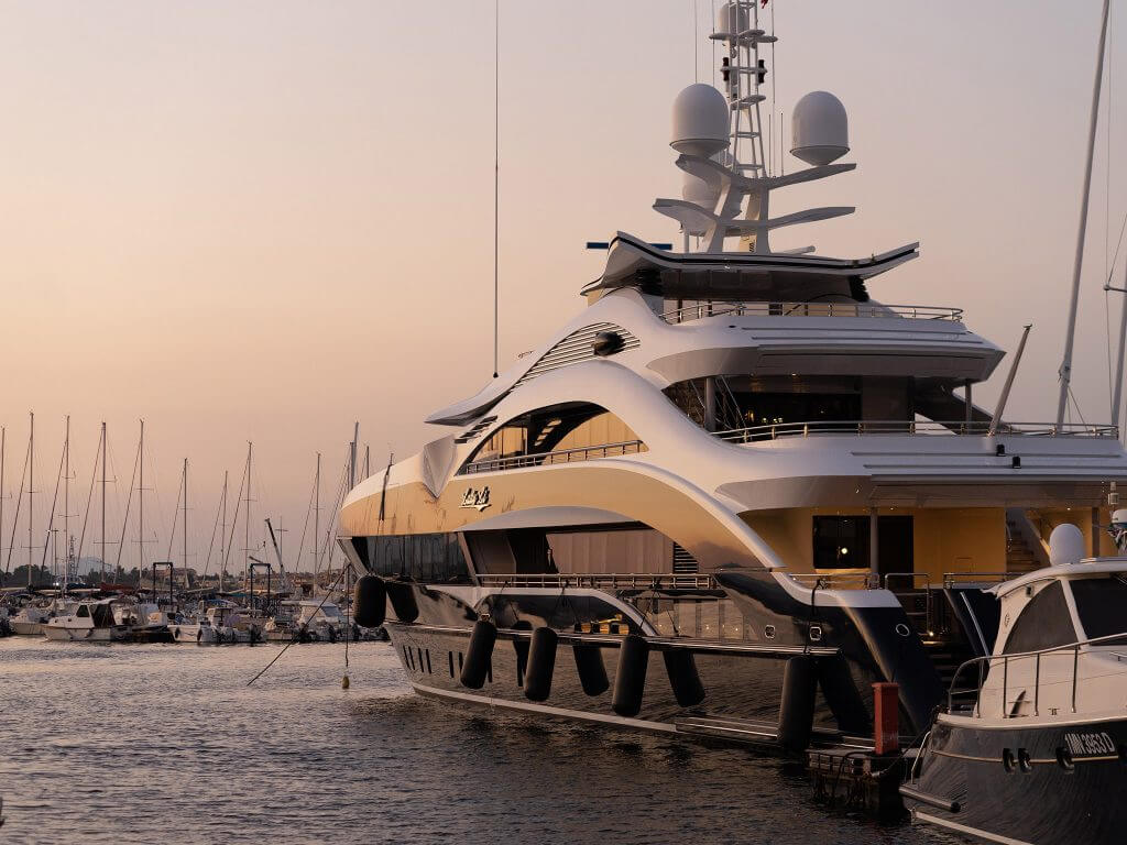 A photo of a luxury yacht docked at sunset.