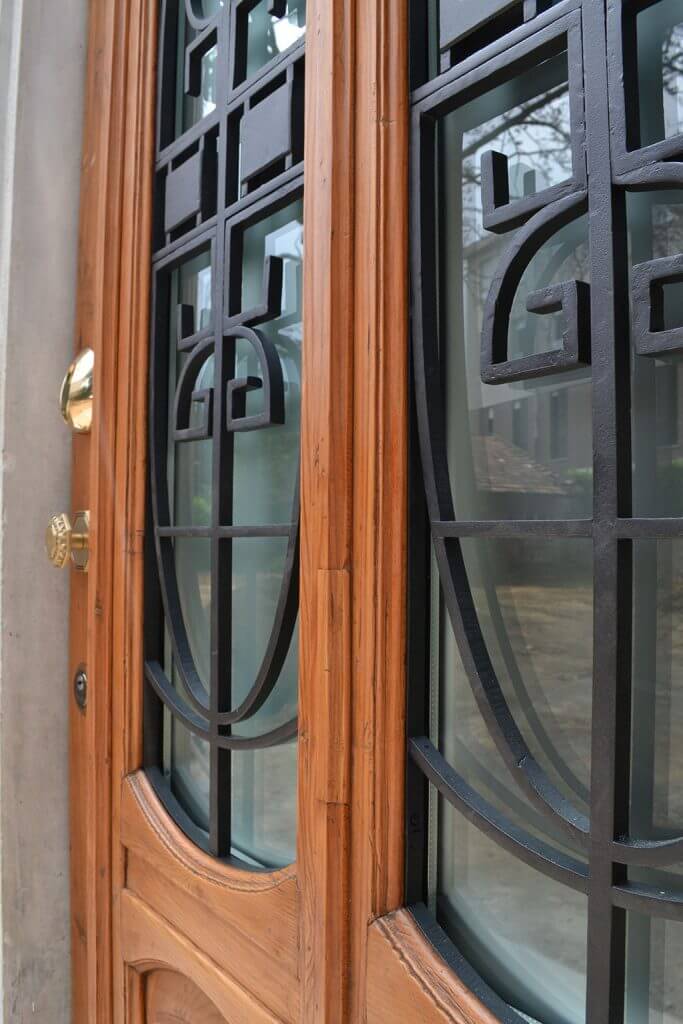 A photo of an elegant steel security front door finished with wood and glass.