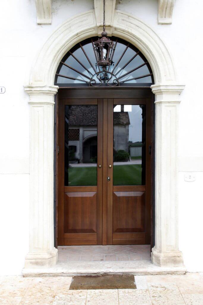 A photo of a steel security door finished with wood and glass accents.